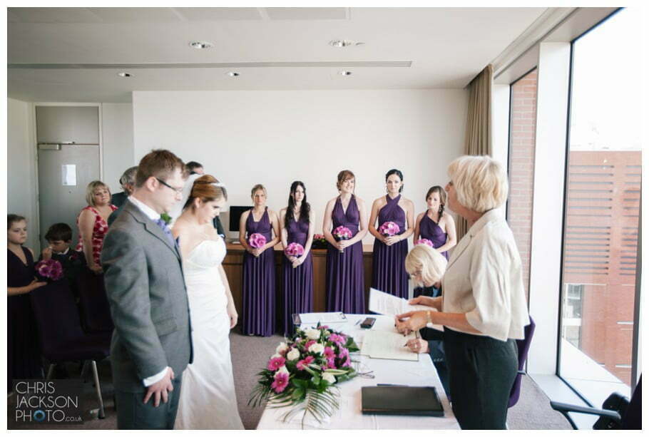 Doubletree by Hilton Wedding Photographer Leeds City Centre Wedding by Chris & Hazel Wedding photography - Tina & Sam 053 bridesmaids stood with bride at front of wedding ceremony leeds doubletree by hilton wedding ceremony room
