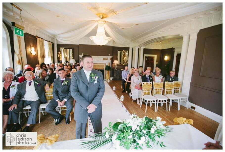 groom waiting for bride at altar front of wedding ceremony room ballroom documentary reportage Eaves Hall Wedding Photographer Lancashire Clitheroe Wedding Photography by Chris & Hazel Wedding Photography - Steph Blight Steph Duxbury & Iain Duxbury