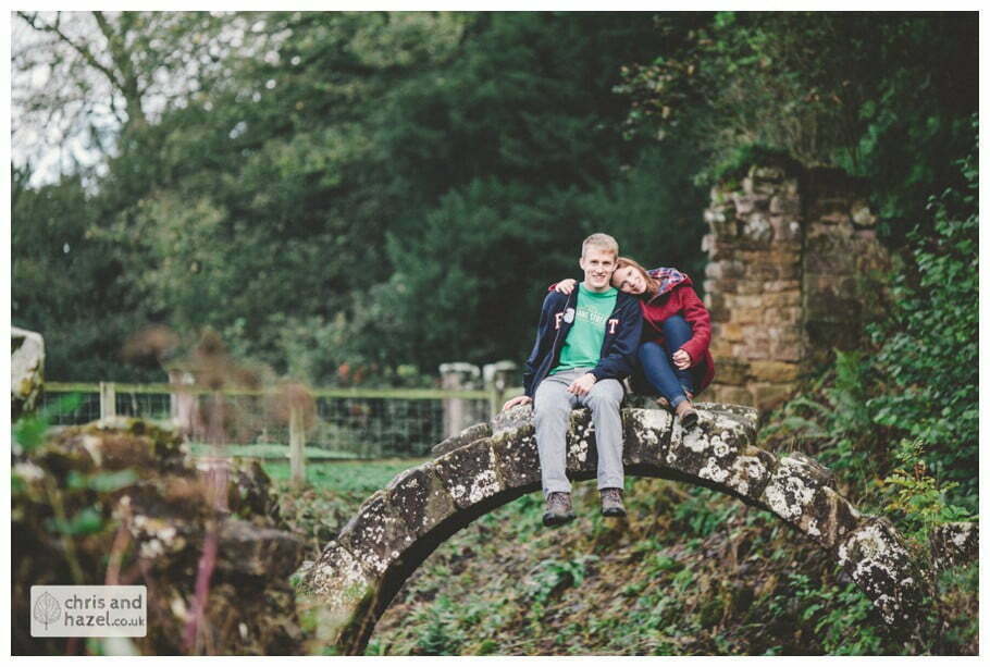 Rippon engagement photography wedding photographer Fountains Abbey yorkshire wedding photographer chris and hazel ruins couple sat on bridge over stream