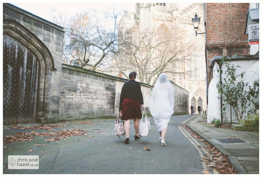 bride walking through york city centre in wedding dress ben frankie wedding photographer york wedding photography bride and groom christmas wedding winter chris and hazel wedding photography york