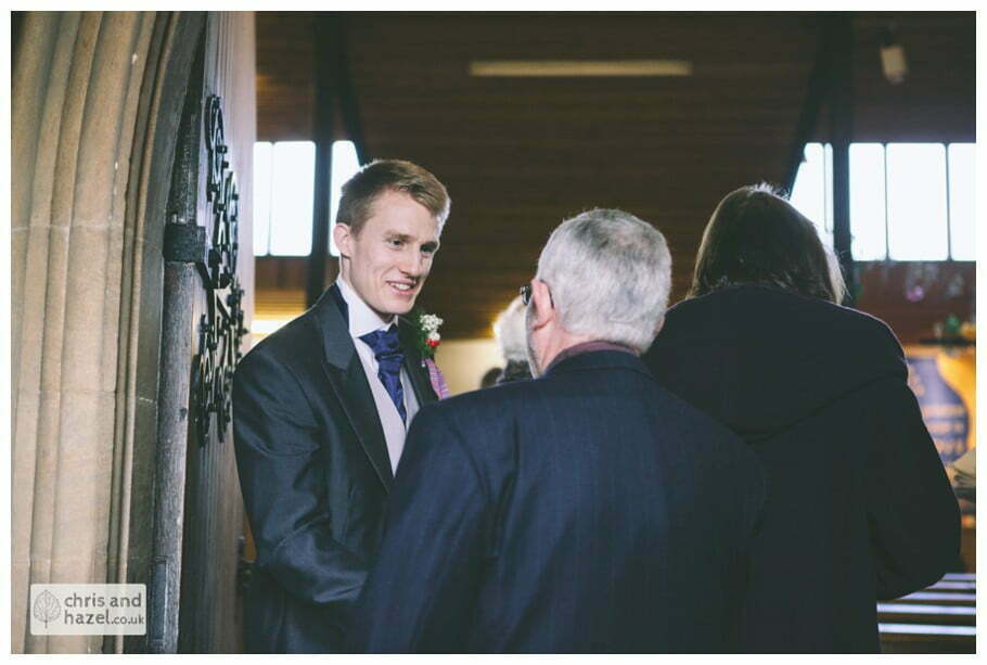 groom and ushers with guests inside heslington church documentary wedding photography ben frankie wedding photographer heslington church wedding york wedding photography wedding winter chris and hazel wedding photography york