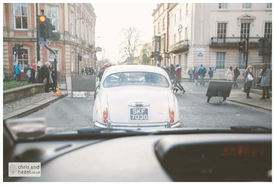 bridal car driving through york city centre heslington church merchant adventurers hall documentary wedding photography ben frankie wedding photographer heslington church wedding york wedding photography wedding winter chris and hazel wedding photography york