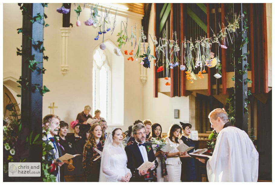 hanging flowers over alter heslington church documentary wedding photography ben frankie wedding photographer heslington church wedding york wedding photography wedding winter chris and hazel wedding photography york