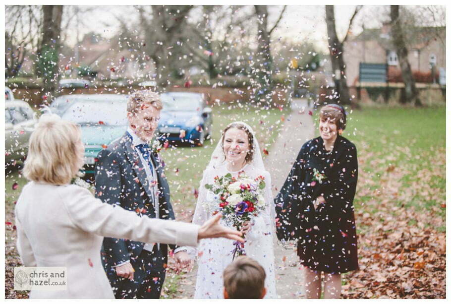 bride and groom confetti shot covered in confetti ben frankie bride groom wedding photographer heslington church wedding york wedding photography bride wedding winter chris and hazel wedding photography york